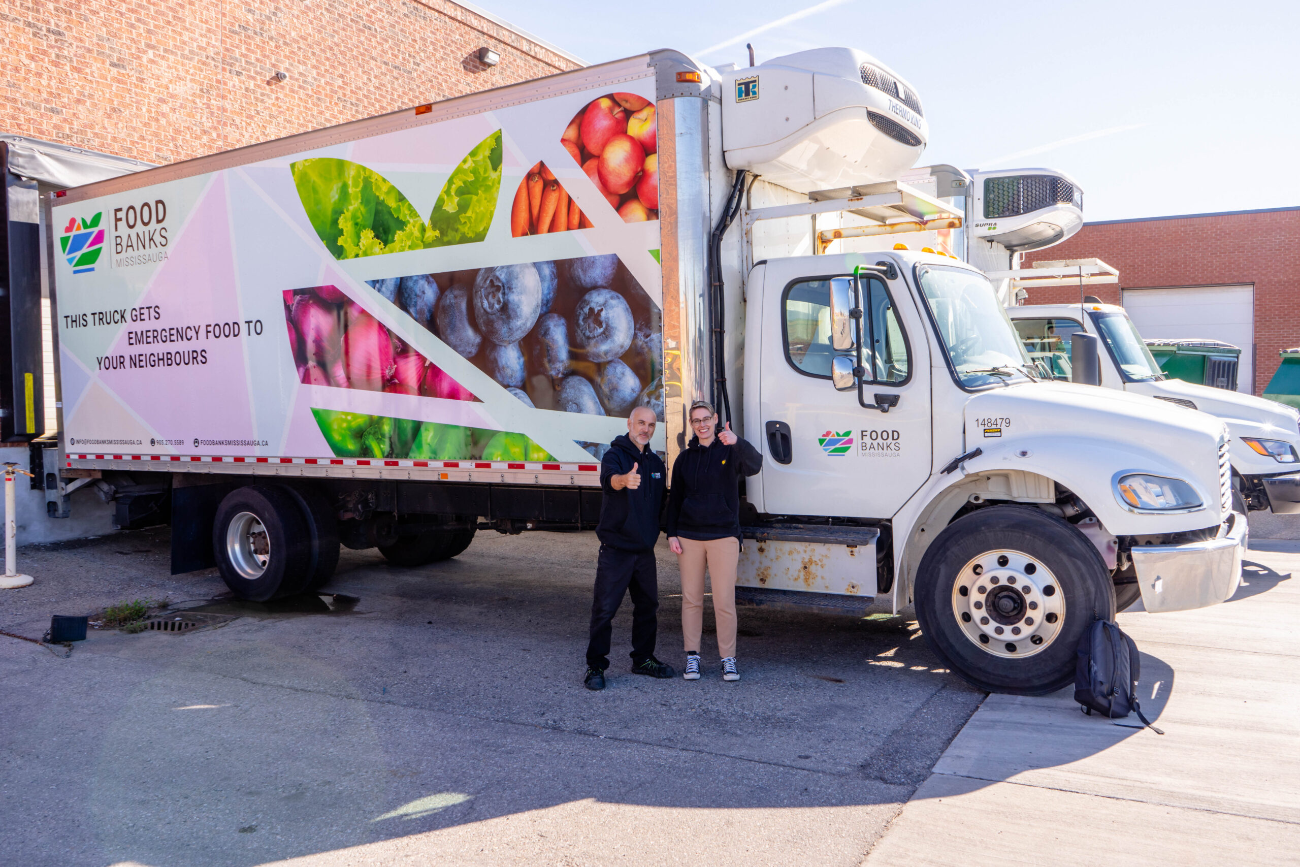 Food Banks Canada CEO Kirstin Beardsley and Food Banks Mississauga driver Steve Dutton stand in front of a delivery truck